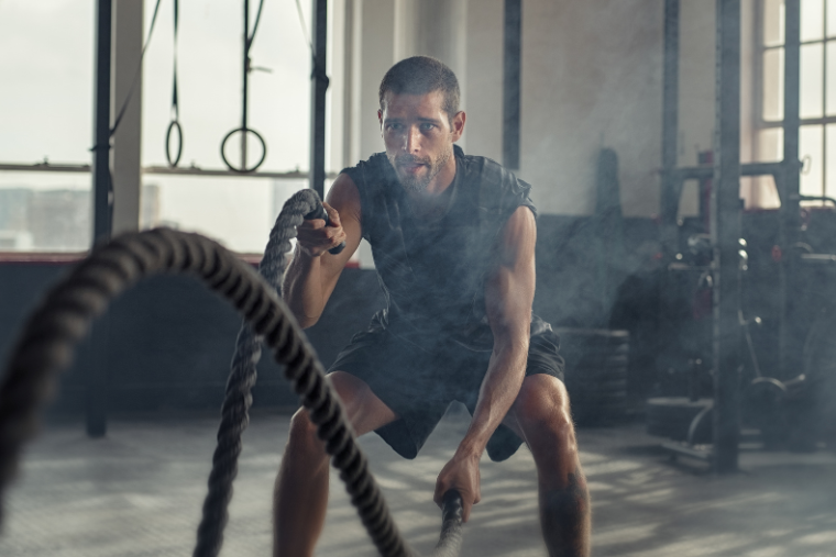 man training with ropes at the gym